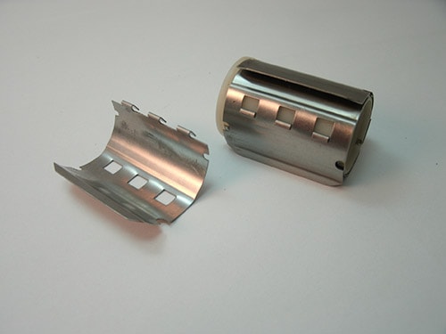 Printer Clutch part assembly shows a plastic roller covered with Finger Spring parts made of 302 half hard stainless steel. The steel parts were produced on a Nilson 2F fourslide.