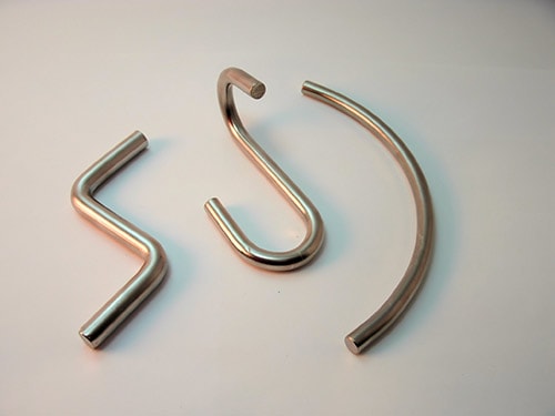 These larger wire forms made of basic steel wire have diameters of .250 and .312. Formed on our Nilson S4 fourslide.